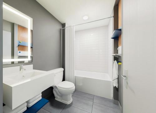 a white bathroom with a sink and a toilet at Microtel Inn Suites by Wyndham Lac-Megantic in Lac-Mégantic