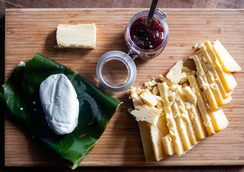 a wooden cutting board with cheese and crackers and dip at SALT LIPS - Azores Surf Experience in Ponta Delgada