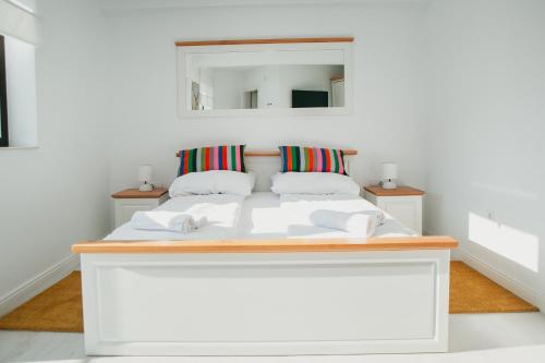 a white bed in a room with a mirror at Chalet 2B in Cavnic
