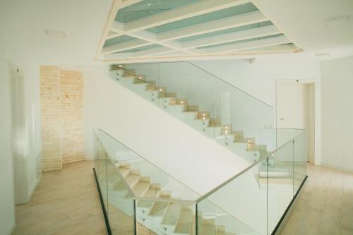 a glass staircase in a white room with a brick wall at Chalet 2B in Cavnic