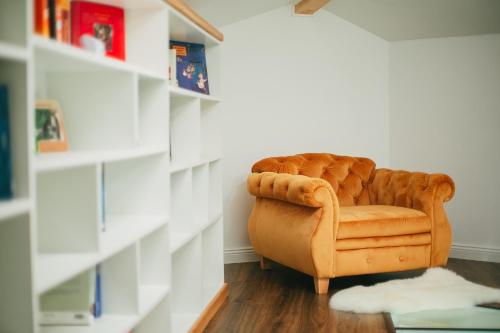 a brown chair in a room with bookshelves at Chalet 2B in Cavnic