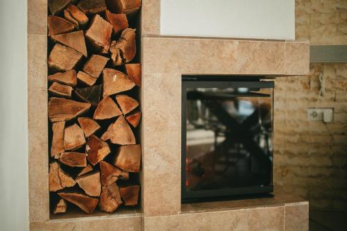 a fireplace with a pile of wood next to it at Chalet 2B in Cavnic
