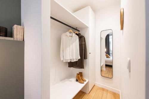 - un couloir blanc avec un miroir et un dressing dans l'établissement Central and renovated Parisian apartment, 6-7 guests, à Paris