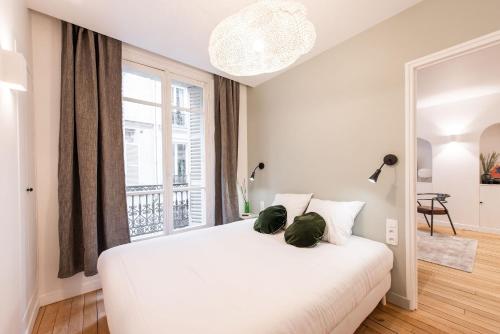 une chambre blanche avec un grand lit et une fenêtre dans l'établissement Central and renovated Parisian apartment, 6-7 guests, à Paris