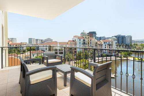 a balcony with chairs and tables and a view of the water at Island Club Luxury Apartments in Cape Town
