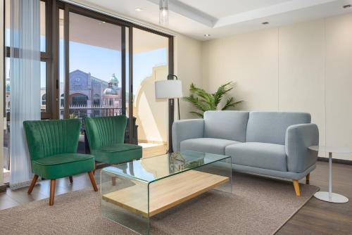 a living room with a couch and two chairs and a glass table at Island Club Luxury Apartments in Cape Town
