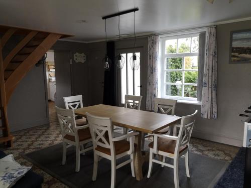 a dining room with a wooden table and chairs at Vacation Home Mechelhof in Leffinge