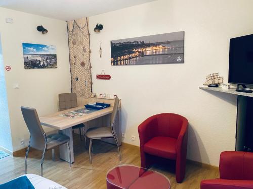 um quarto com uma mesa e cadeiras e uma televisão em STUDIO CANCALE - PORT DE LA HOULE - classé 2 étoiles em Cancale