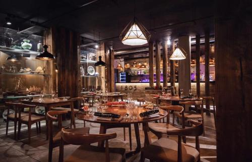 a restaurant with wooden tables and chairs and a bar at Stay@Coast in Bournemouth
