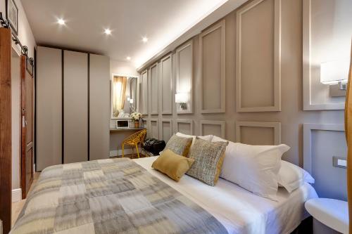 een slaapkamer met een groot bed met witte kussens bij Neri apartment in Florence
