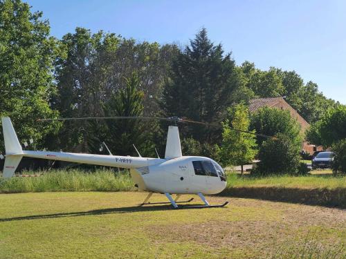 a small white helicopter sitting on the grass at Domaine De Pradaous in Reillanne