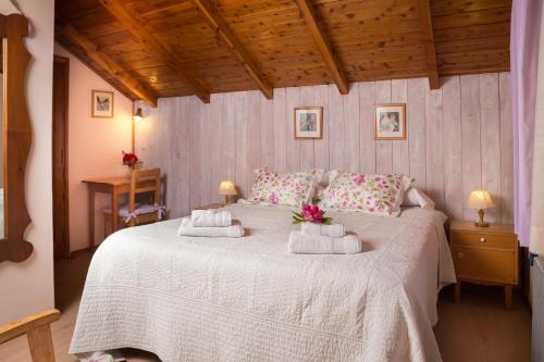 um quarto com uma cama branca e toalhas em Hosteria Katy em San Carlos de Bariloche