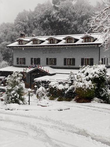 a house covered in snow in front at Hotel Al Verde in Mandello del Lario