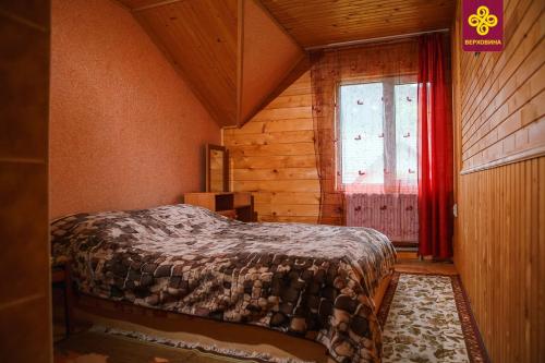 1 dormitorio con 1 cama en una habitación con ventana en Садиба Анничка, en Krivorovnya