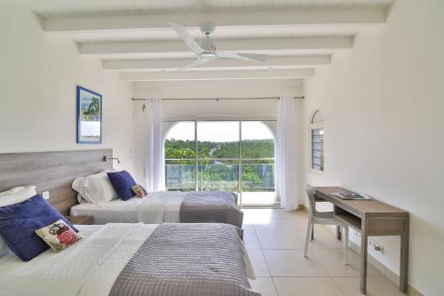 a bedroom with two beds and a desk and a window at Dream Villa Terres Basses 569 in Les Terres Basses