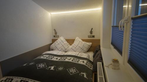 um pequeno quarto com uma cama com almofadas em Apartment Fleißner em Dienten am Hochkönig