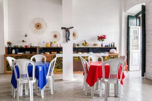 ein Esszimmer mit Stühlen und einem Tisch mit roten und blauen Decken in der Unterkunft Pousada Cor e Arte - Pelourinho in Salvador