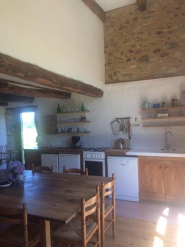 a kitchen with a wooden table and a table and chairs at Aveyron West in Saint-Igest