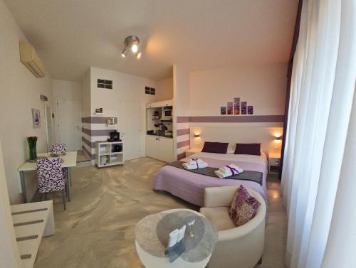 ein Schlafzimmer mit einem Bett, einem Sofa und einem Tisch in der Unterkunft Minisuite in Bologna