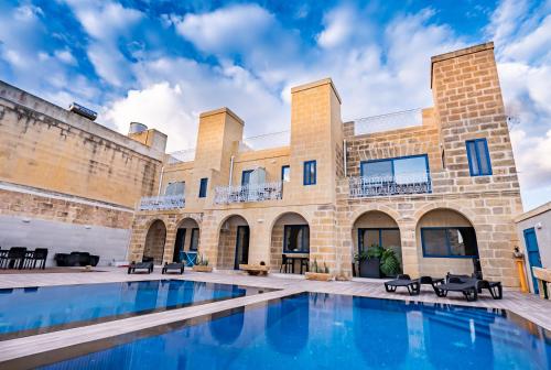 an exterior view of a building with a swimming pool at Fiftyfour West Boutique Living in Għarb