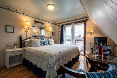 a bedroom with a bed and a balcony at A Cape Cod Ocean Manor Inn in Hyannis
