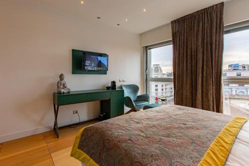 a bedroom with a bed and a desk and a window at Missori Suites in Milan