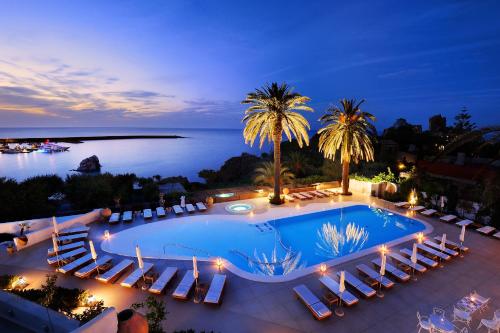 an overhead view of a pool with chairs and the ocean at Le Calette Bay in Cefalù
