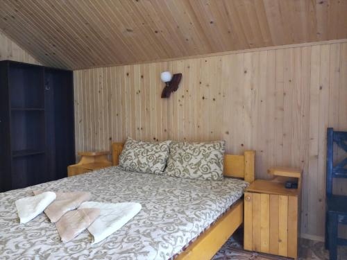 ein Schlafzimmer mit einem Bett in einer Holzwand in der Unterkunft Уютный котедж "Hatynka" in Jablunyzja