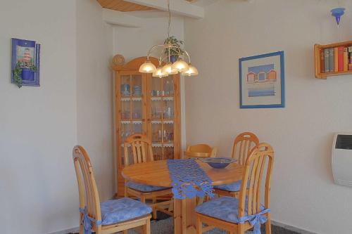 - une salle à manger avec une table et des chaises en bois dans l'établissement Seestern Bungalow STW45b, à Dorum Neufeld