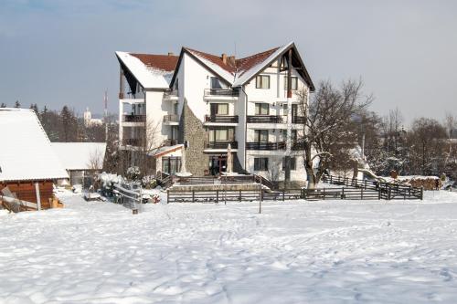 a large building in the snow with snow covered ground at Vila Alisa in Bran