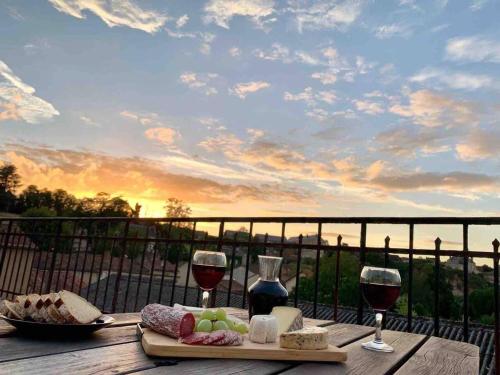 - une table avec de la nourriture et des verres à vin sur le balcon dans l'établissement 2 Bed-Roof Terrace-Town Centre-Pets, à Montmorillon