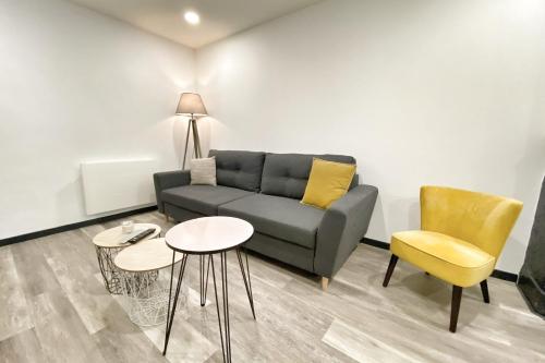 a living room with a couch and two tables and chairs at Le Grand Frontalier in Terville