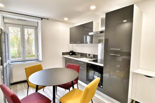 une cuisine avec une table et des chaises dans une cuisine dans l'établissement Le Grand Frontalier, à Terville