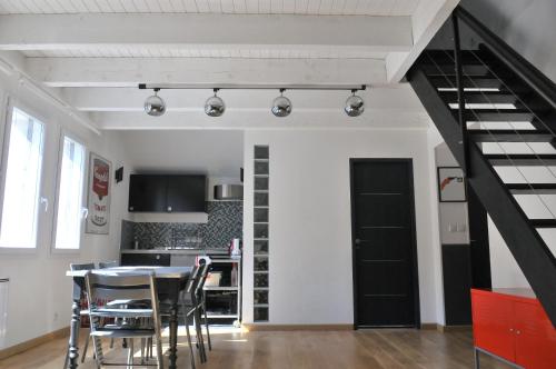 een keuken en eetkamer met een zwarte wenteltrap bij Studio Alpins in Annecy