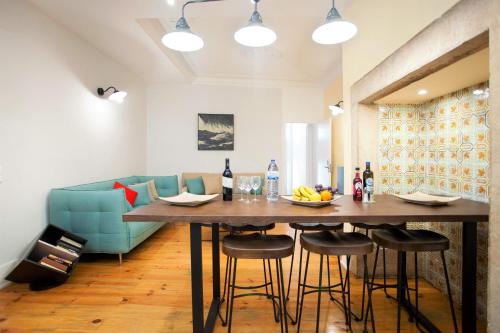 a living room with a table and a blue couch at Contador Mor Rooms and Apartments in Lisbon