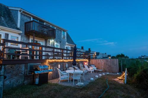 a patio with a table and chairs in a backyard at A Cape Cod Ocean Manor Inn in Hyannis