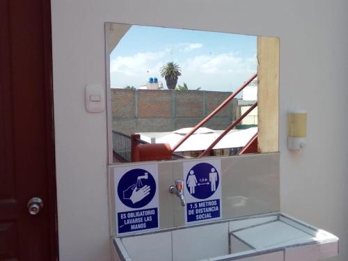a mirror in a bathroom with a reflection of a window at Gran Hotel in Arequipa