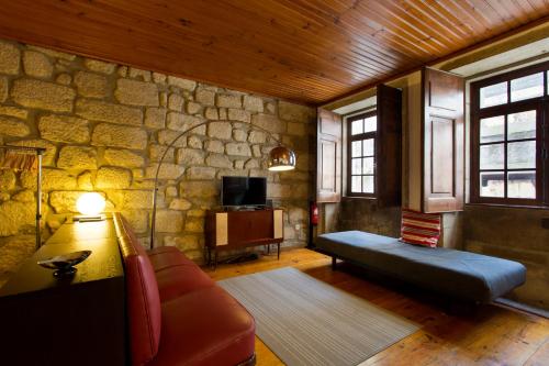 a living room with a couch and a stone wall at Charming Ribeira Apartment 328 feet Douro River Unesco in Porto