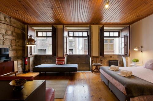 a bedroom with a bed and a couch in a room at Charming Ribeira Apartment 328 feet Douro River Unesco in Porto