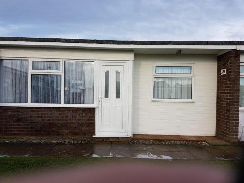 a house with a white door and two windows at alicias chalets ,free WIFI & swimming pool passes in Great Yarmouth