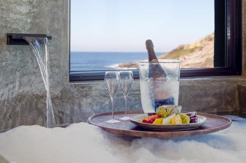 a table with a plate of fruit and wine glasses at Well Hotel & Spa in Maceira