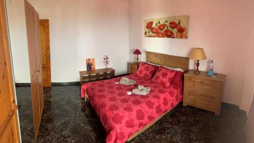 a bedroom with a bed with a red bedspread at Naomi’s House in Fasnia