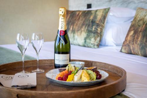 a bottle of wine and a tray of food and wine glasses at Well Hotel & Spa in Maceira