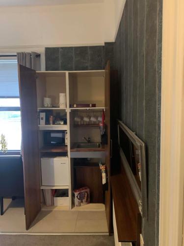 a book shelf in a room with a tv at Upstairs Studio - Private kitchenette and Small en-suite in Dublin