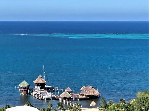 a dock with chairs and umbrellas on the water at Stunning Turquoise Views From This 2 Bedroom, 2 Bath Home,,, in French Harbour
