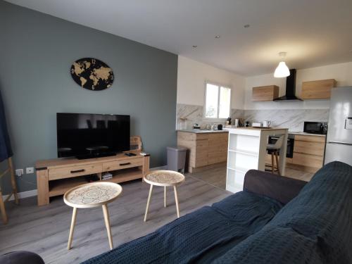 un salon avec un canapé et une cuisine dans l'établissement Beau T4 lumineux au calme, grande terrasse, à Roques
