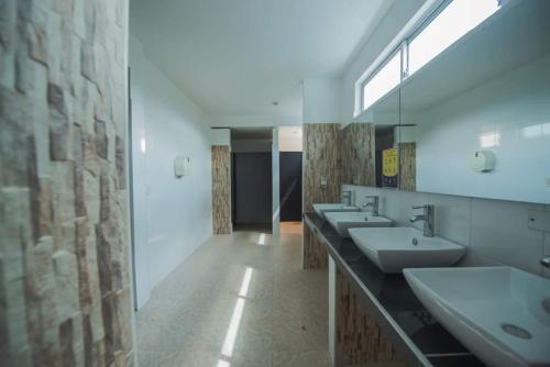 Baño con 4 lavabos y una fila de espejos en HOTEL CAMPESTRE LA MONTAÑA, en Girardot