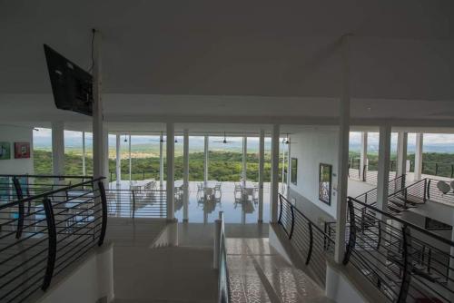 a large room with glass walls and ceilings with tables at HOTEL CAMPESTRE LA MONTAÑA in Girardot