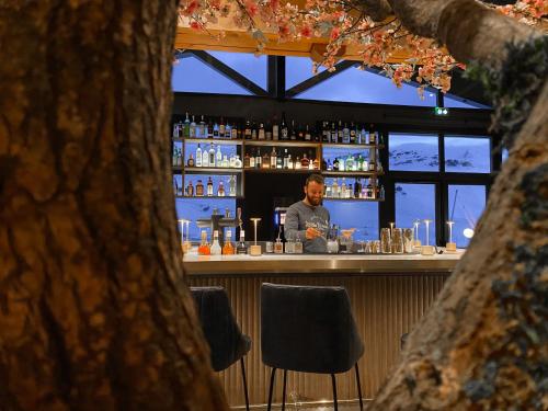 a man standing behind a bar in a restaurant at Hôtel Marielle in Val Thorens