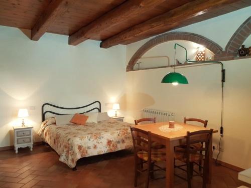 プラトヴェッキオにあるAgriturismo Lucatelloのベッドルーム1室(ベッド1台、テーブル、椅子付)